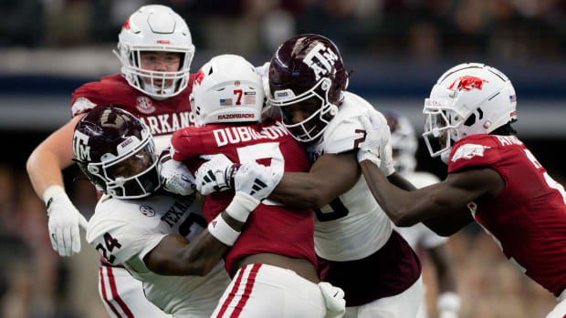Sep 30, 2023; Arlington, Texas, USA; Arkansas Razorbacks running back Rashod Dubinion (7) is tackled by Texas A&M Aggies linebacker Chris Russell Jr. (24) and defensive back Jacoby Mathews (2) during the first half at AT&T Stadium. Mandatory